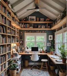 a home office with lots of bookshelves and plants