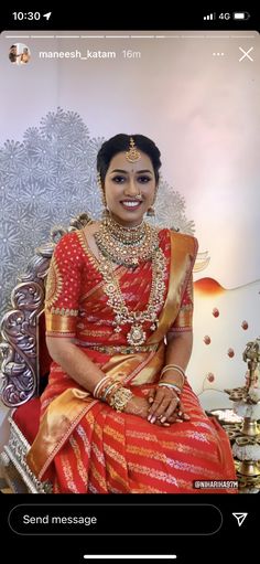 a woman sitting on top of a chair wearing a red and gold dress