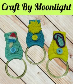 three crocheted keychains are sitting on a wooden table with the words craft by moonlight written above them