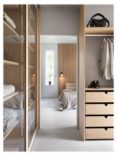 an open closet with clothes hanging on the shelves and shoes sitting on the dressers