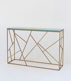 a glass and metal console table against a white background