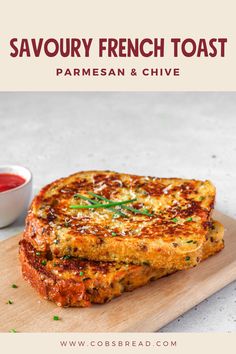 two pieces of parmesan and chive french toast on a wooden cutting board