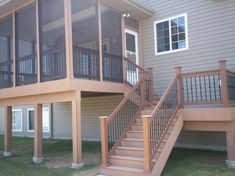 a deck with railings and stairs in front of a house