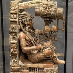 an ancient statue is displayed in a glass case