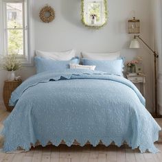 a bedroom with white walls and blue bedding