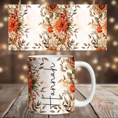 two coffee mugs sitting on top of a wooden table next to each other with flowers