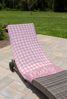 a pink and white checkered towel sitting on top of a lawn