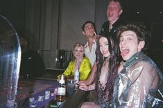 a group of people sitting at a table with bottles and drinks in front of them