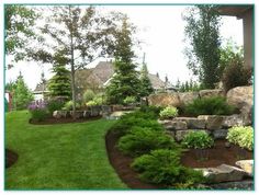 a garden with rocks, grass and trees