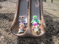 three stuffed animals sitting on top of a slide