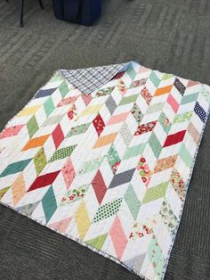 a multicolored quilt on the ground in an office