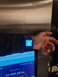 someone is using their samsung smartwatch to check out the water dispenser