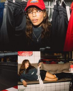 a woman wearing a red hat and glasses sitting on a bench in front of clothes