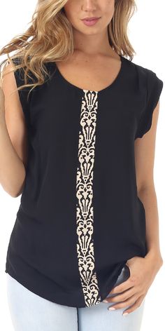 a woman wearing a black top with white designs on it