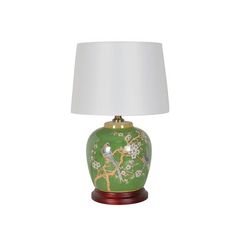 a green lamp with a white shade on it and a bird design on the base