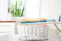 a wicker basket filled with folded towels on top of a table