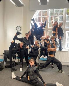 a group of people are posing for a photo in front of a mirror with their hands up