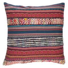 a multicolored striped pillow with fringes on the front and back, sitting on a white background