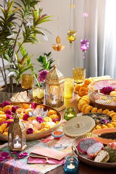 the table is covered with plates and bowls filled with flowers, candles, and other decorative items