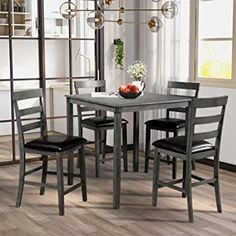 a dining table set with four chairs and a bowl of fruit on the counter top