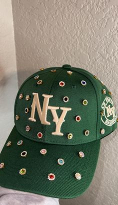 Adjustable NY Custom Bedazzled Hat customed by ShanayCosmetics Comes in 2 colors: Black or Green New Restock Coming Soon with colors Pink & Denim. Green and Black will be returning as well. PLEASE KEEP IN MIND THAT I AM NOT RESPONSIBLE FOR ANY DELAYS WITH SHIPPING ONCE I HAVE DROPPED YOUR PACKAGE OFF AT THE POST OFFICE! THAT IS OUT OF MY CONTROL. PLEASE BE AWARE I AM NOT RESPONSIBLE FOR ANY LOST, DAMAGED OR STOLEN PACKAGES!! Trendy Snapback Baseball Cap With Rhinestones, Trendy Rhinestone Snapback Baseball Cap, Trendy Rhinestone Hats For Spring, Trendy Rhinestone Baseball Cap, Trendy Snapback Hat With Rhinestones, Trendy Rhinestone Cap, Trendy Rhinestone-embellished Cap, Green Ny Hat, Ny Hat Outfit