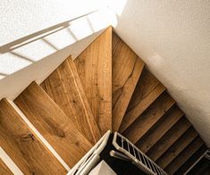 an overhead view of a wooden staircase with metal handrails