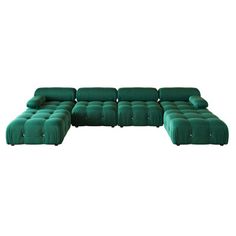 a large green couch sitting on top of a white floor