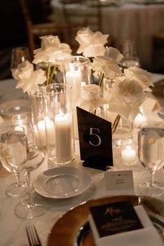 the table is set with white flowers and candles