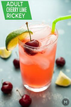 a close up of a drink with cherries on the rim and lime garnish