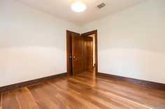 an empty room with hard wood floors and white walls is pictured in this image taken from the doorway