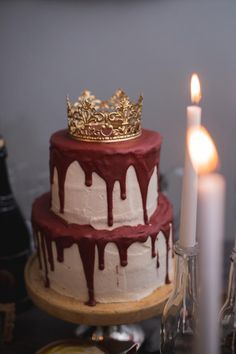 a red and white cake sitting on top of a table next to a lit candle