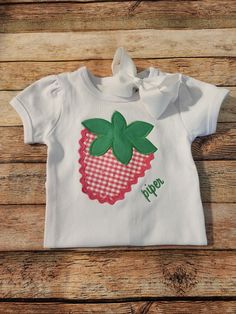 This custom strawberry shirt is a hit all year round! Perfect for strawberry festivals, summer staple and birthdays too!  I use high quality shirts for embroidery and they are 100% cotton that soft and run TTS.  This listing is for one puff sleeve shirt not a tank. If you would like a tank as shown please message me based on availability. (Tanks will not be ribbed)  Shirts are available in 12M-10Y. Onesies are available from sizes 0-3m to 18m. BOW IS NOT INCLUDED IN THIS LISTING.  Fabrics may slightly differ but will be from the same patterns and color scheme pictured.  Please let me know if you'd like any changes made when placing your order. If you'd like something different please message me! When ordering don't forget to include the full name and thread color you would like in the note Cute Strawberry Print Shirt For Spring, Fitted Cotton T-shirt With Strawberry Print, Pink Strawberry Print Shirt For Spring, Sweet Cotton Summer Shirt, Sweet Summer Cotton Shirt, Sweet Cotton Shirt For Spring, Playful Embroidered Short Sleeve Tops, Cute Summer Shirt With Strawberry Print, Cute Strawberry Print Shirt