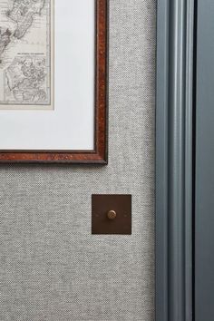 a framed map hangs on the wall next to a blue cabinet with a brown drawer