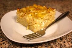 a white plate topped with a piece of cake next to a fork