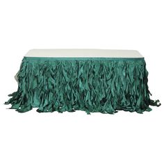 a green tablecloth with fringes on it and a white cloth underneath the table