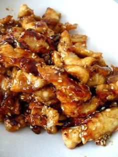 chicken with sesame seeds and sauce on a white plate