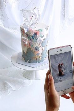 someone taking a photo of a cake on their phone