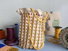 a bag sitting on top of a table next to spools of thread