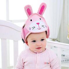 a baby wearing a pink bunny hat with ears