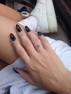 two hands with black and white nail polishes on their fingers, one has a crescent shaped