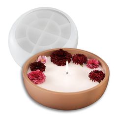 a candle that is sitting in a bowl with flowers on the bottom and inside it