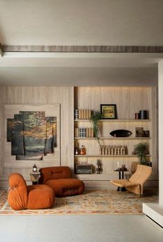 a living room filled with furniture and bookshelves next to a wall mounted shelf