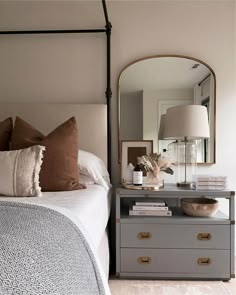 a bedroom with a bed, dresser and mirror in it's centerpieces