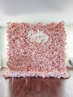 a pink flowered wall with a chair in front of it that says bride to be