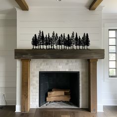 the fireplace is decorated with black and white pine trees on each mantel, along with wood flooring