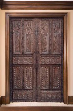 an ornate wooden door with intricate carvings on the front and side panels, is shown