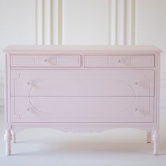 a pink dresser with two drawers sitting on top of it