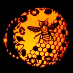 a carved bee and honeycomb with flowers on it's side in the dark