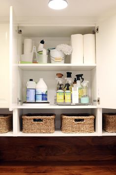 the shelves in this bathroom are filled with cleaning products and toiletries, along with baskets