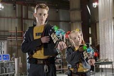 two young people standing next to each other in a warehouse with lights on their hands